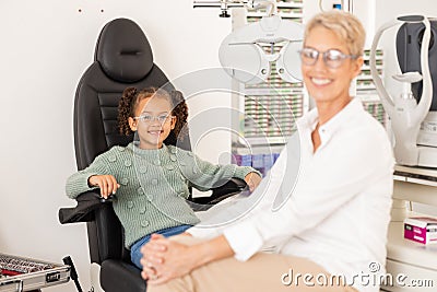 Children, vision and glasses with a girl customer and optometrist consulting in an office for an eye test. Portrait Stock Photo