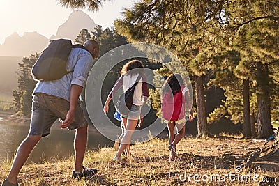 Children Walk By Lake With Parents On Family Hiking Adventure Stock Photo