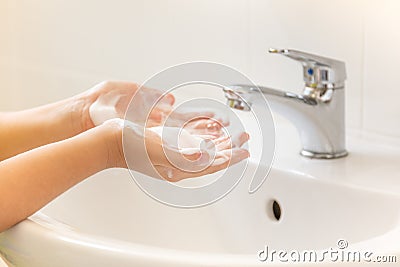 Children washing hand with foam soap in bathroom sink Stock Photo