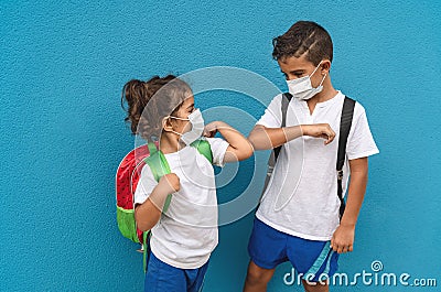 Children wearing face protective mask going back to school during corona virus pandemic - Little kids doing new social distance Stock Photo