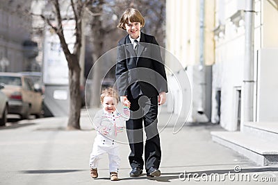 Children wearing formal clothes on sunny street Stock Photo