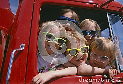 Children wearing sunglasses in red truck Editorial Stock Photo