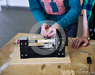 Children work in the training center on wood processing machines. Stock Photo