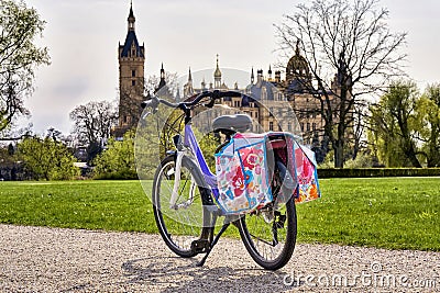 Children's bicycle with saddlebags in the park, with Schwerin Castle in the background Stock Photo