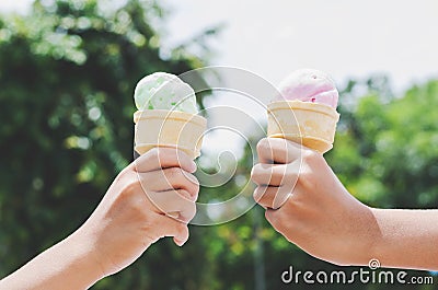 children& x27;s hands holding ice cream cone on summer light nature b Stock Photo