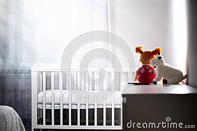 Children& x27;s room with an empty cradle and toys on the dresser. Copy space.Concept of abortion and female infertility Stock Photo