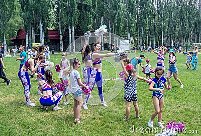 Children and young women â€“ volunteers, participating at cheerleading training Editorial Stock Photo