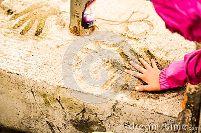 Childrens hand fitting in concrete Stock Photo