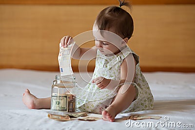 Childrens hands with money in glass jar Stock Photo