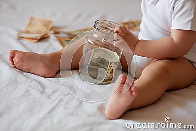 Childrens hands with money in glass jar Stock Photo