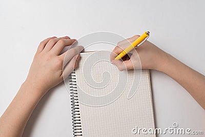 Childrens hands writing in notebook. Child doing homework. Top view white background Stock Photo