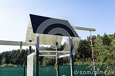 A childrens playground made of wood and painted white and navy blue, visible roof covered with felt. Stock Photo