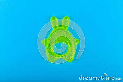 childrens toy for teeth. in the form of a hare. Green colour. Brush your teeth. on a blue background. Place for an inscription. Stock Photo