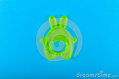 Childrens toy for teeth. in the form of a hare. Green colour. Brush your teeth. on a blue background. Place for an inscription. Stock Photo