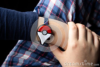 Childs hand with new Japanese game Pokemon go plus made by The Pokemon company Nintendo. Editorial Stock Photo