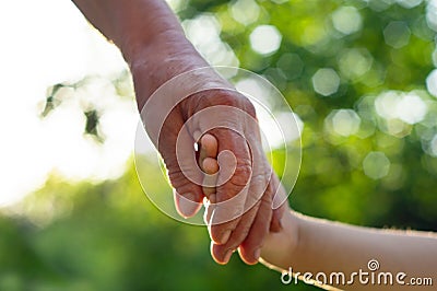 Childs hand and old hand grandmother. Concept idea of love family protecting children and elderly people grandmother Stock Photo