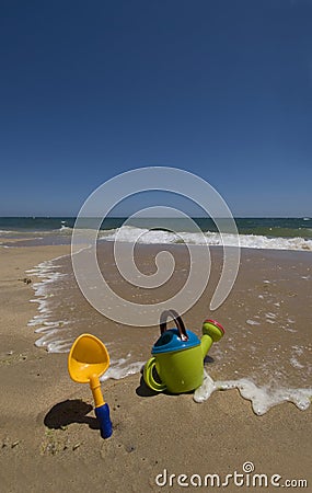 Childs sand bucket and toys on scenic sunny beach Stock Photo