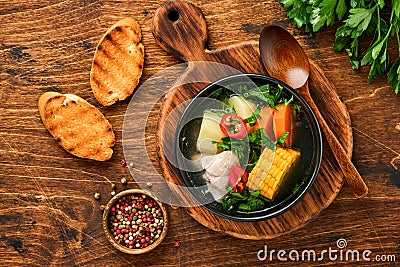 Chilean meat soup with pampkin, corn, fresh coriander and potatoes on old wooden table background. Cazuela. Latinamerican food. Stock Photo
