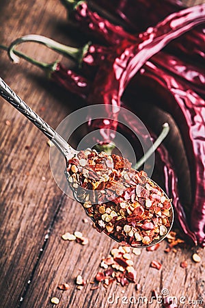 Chili. Chili peppers. Several dried chilli peppers and crushed peppers on an old spoon spilled around. Mexican ingredients Stock Photo