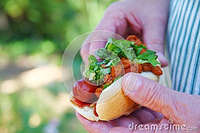 Man holding chili dog outdoors Stock Photo