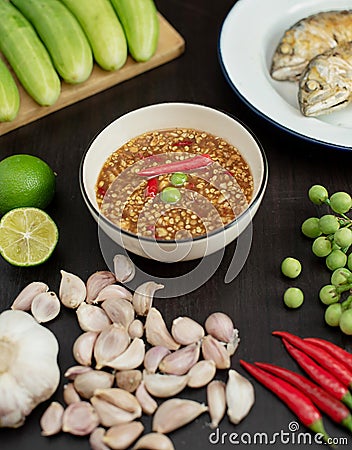 Chili paste thai language Nam prik kapi in a white bowl with ingredients and Fried steam mackerel on the table Stock Photo