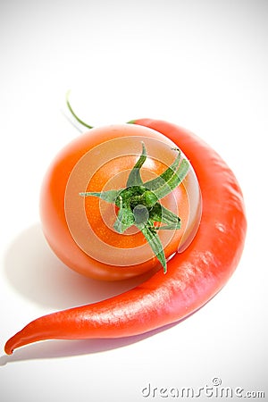 Chili peppers and tomato next to each other Stock Photo