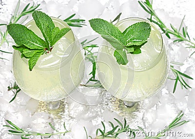 Chilled drink with mint leaves in cocktail goblets on ice cubes. Summer beverage. Bar menu. Cold mojito. Refreshing lemonade Stock Photo