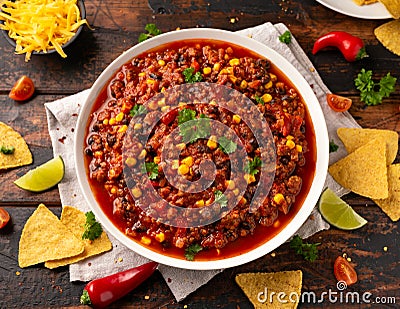 Chilli con Carne with tortilla chips and cheese in white bowl. Mexican food. Stock Photo