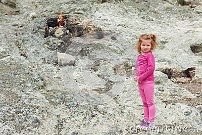 Chimera fire. Baby girl poses for the camera on a hill near Chirali. Kemer. Turkey. Stock Photo