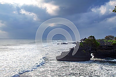 Chimeric temple on the water. Water temple in Bali. Indonesia nature landscape. Famous Bali landmark. Splashing waves Stock Photo