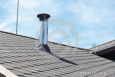 Chimney pipe from stainless steel on the roof of the house. Stock Photo