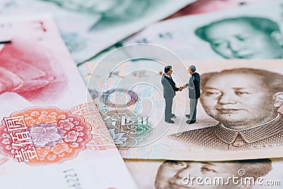 China finance tariff trade war negotiation talk concept, miniature people businessman leader handshaking on Chinese yuan banknote Stock Photo