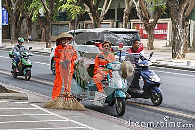 City street cleaners in special clothes with panicles and straw hats Editorial Stock Photo