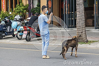 China, Hainan Island, Dadonghai Bay - City street, in the city of Sanya,volunteer help, a Chinese vet rescues a Editorial Stock Photo