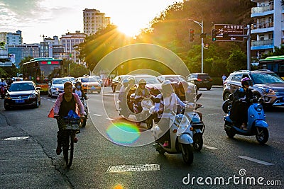 China, Hainan, Sanya - May 13, 2019: Road traffic on the background of the setting sun Editorial Stock Photo