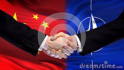 China and NATO handshake, international friendship relations, flag background Editorial Stock Photo