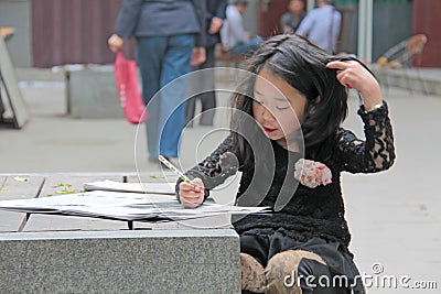 China, Suzhou - April 14, 2012. A Chinese girl draws in a book o Editorial Stock Photo