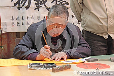 China, Suzhou - April 14, 2012. A man writes calligraphy in Chin Editorial Stock Photo