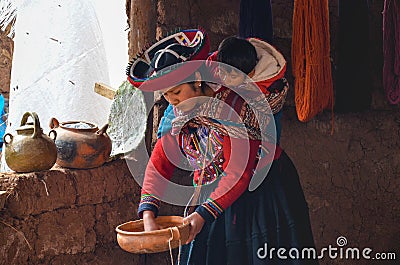 CHINCHERO, PERU- JUNE 3, 2013: Native Cusquena woman dressed in traditional colorful clothing explaining the dyeing threads and we Editorial Stock Photo