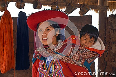 CHINCHERO, PERU- JUNE 3, 2013: Native Cusquena woman dressed in traditional colorful clothing explaining the dyeing threads and we Editorial Stock Photo