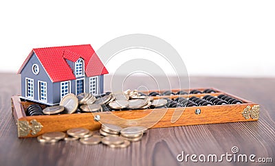 Chinese abacus, small house and scattered euro coins Stock Photo