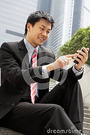 Chinese Businessman Dialling On Mobile Phone Stock Photo