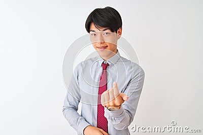 Chinese businessman wearing elegant tie standing over isolated white background Beckoning come here gesture with hand inviting Stock Photo
