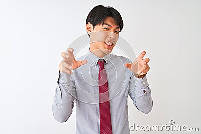 Chinese businessman wearing elegant tie standing over isolated white background smiling funny doing claw gesture as cat, Stock Photo