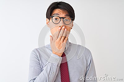 Chinese businessman wearing tie and glasses standing over isolated white background cover mouth with hand shocked with shame for Stock Photo