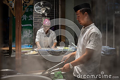 Chinese chef preparing hot food Editorial Stock Photo