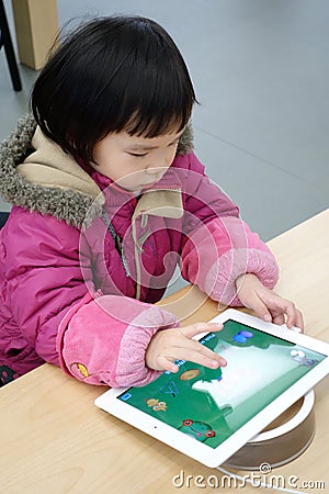 Chinese child playing ipad Editorial Stock Photo