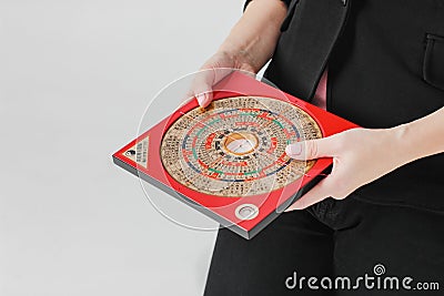 Chinese compass Lopan for Feng Shui technique in female hands is Stock Photo