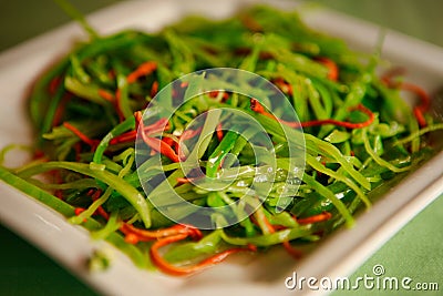 Warm Chinese salad with cabbage and hot pepper, served on a white plate. Stock Photo