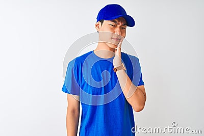 Chinese deliveryman wearing blue t-shirt and cap standing over isolated white background touching mouth with hand with painful Stock Photo